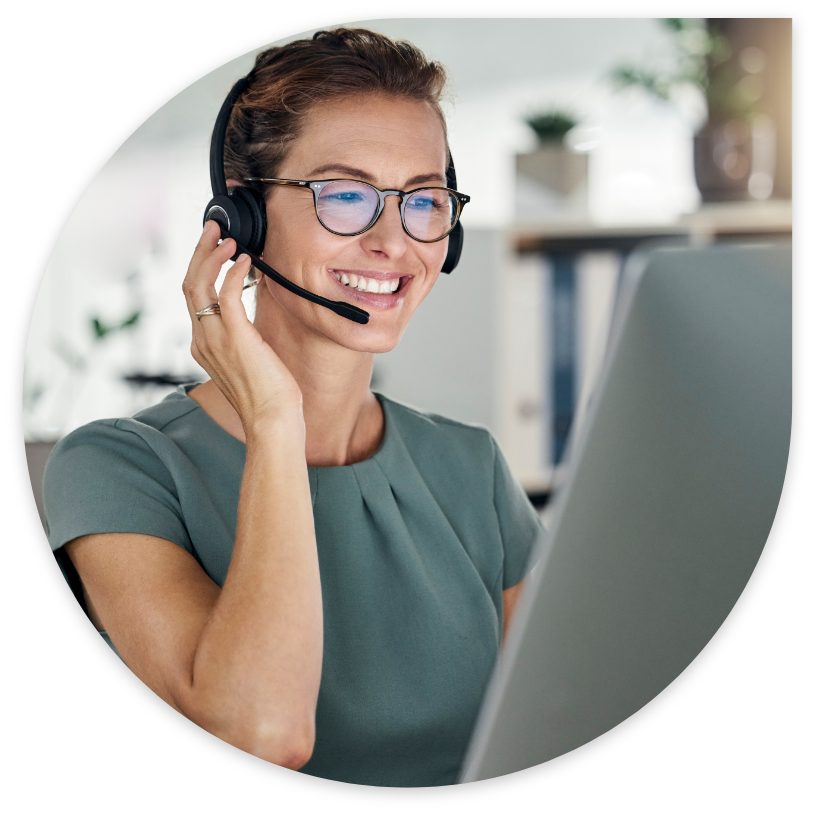 Woman talking through a headset in front of a computer Woman talking through a headset in front of a computer