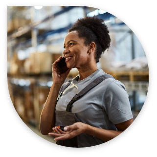 Woman in factory holding a cell phone in her right hand