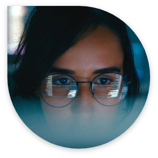 woman with glasses looking into the computer screen